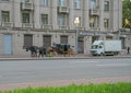 Russia, St. Petersburg, a carriage and a team of horses around the city. Gray urban architecture, gray road, laconic urban look. B