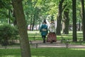 Russia, St. Petersburg, a couple in historical costumes of the era of Peter the Great walks in the park. A bright sunny green summ