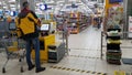 Customers in the checkout area and signs marking the distance to the floor in the supermarket during the coronavirus epidemic