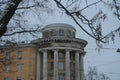 Russia, St. Petersburg, early winter, unusual building, architecture with columns. Close-up, tree branches in the foreground