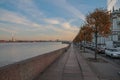 Russia, St. Petersburg, the embankment of the Neva River in autumn, red trees, beautiful blue sky, very gentle sun in the distance