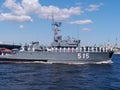 The parade of naval technology. Gray warship with sailors in formal white uniform on board against the background of the