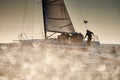 Russia, St.Petersburg, 07 July 2023: The view through the spray of how the sailboat is heeling at sunset, boat roll