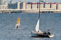 Russia, St. Petersburg, 10 June 2022: The sailing yacht with yachtsmen on board floating at sunset, residential complex