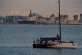 Russia, St. Petersburg, 10 June 2022: The sailing yacht with yachtsmen on board floating to port at sunset, residential