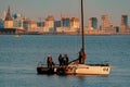 Russia, St. Petersburg, 10 June 2022: The sailing yacht with yachtsmen on board floating to port at sunset, residential