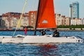 Russia, St. Petersburg, 10 June 2022: The trimaran with professional yachtsmen on board floating at sunset, residential