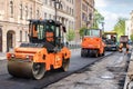 RUSSIA, ST.PETERSBURG - MAY 12, 2019: Repair of roads. Orange asphalt pavers, burgundy truck and workers in coveralls