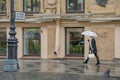 Russia, St. Petersburg, rain in the city, a woman with a white umbrella, shop windows, lyrical thoughtful urban rainy landscape