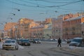 Russia, St. Petersburg, winter city landscape. The road, cars, beautiful pink and yellow buildings, a gentle blue sky, a man is wa