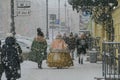 Russia, St. Petersburg, winter. Winter city street, snowfall, snow. Passers-by in the clothes of the last century. Historical St.