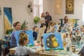 Russia, Tatarstan, April 21, 2019. Children`s drawing class. Easel, canvases, paints on the table. A group of children draw