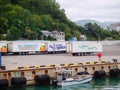 Russia, Tuapse 15.11.2020. Large white cargo vans with logos and lettering stand on the marina against the backdrop of