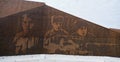 Rusty wall of memory with image of Russian soldiers and inscriptions of names and surnames of those killed in battle