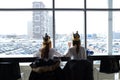Russia, Tyumen, 30.03.2019. Teenage girls in crowns from Burger king for lunch at the Mall. Girls eat in the shopping center. Rear