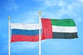 Russia and United Arab Emirates two flags on flagpoles and blue cloudy sky Royalty Free Stock Photo