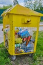 Russia, Vladimir, 02.06.2021, Yellow container for household garbage filled with garbage stands on the street.