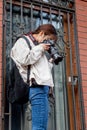 Russia, Vladivostok, 05/09/2018. Nice asian lady photographer with a modern digital camera takes a photo standing at a barred