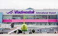 Passenger airplanes Airbus A320 of S7 Airlines on airfield in cloudy day. Airport terminal on background