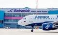 Passenger jet aircraft Airbus A319 of Aurora Airlines on airfield. Terminal of airport on background. Aviation and transportation Royalty Free Stock Photo