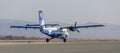 Passenger plane De Havilland CanadaDHC-6-400 of Aurora Airlines on runway, back view. Turboprop engine.