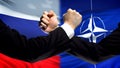 Russia vs NATO confrontation, countries disagreement, fists on flag background