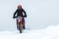 Russia Vyborg 02.23.2021 on a red motorcycle racer rides through the snow outside the city Royalty Free Stock Photo