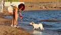 Russia. Vyborg. 07.07.2019 slender girl walks with dogs on the shore of the lake