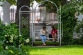 Two young women talking while sitting on a swing in the Governor`s in Yaroslavl, Russia. 05.08.2020.