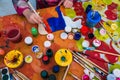 Russia, Yaroslavl city - May 4, 2019: The child holds a brush. Coloring a wooden board. Creative studio or drawing lesson.