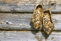 Russian bast shoes and wooden wall Royalty Free Stock Photo