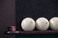 Russian Billiards. three billiard balls on the shelf stand and chalk whiten the tip of the cue Royalty Free Stock Photo