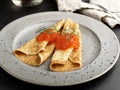 Russian Blinis with red caviar on a gray plate closeup