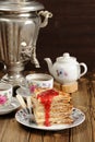 Russian bliny with raspberry jam, vintage samovar and teaware Royalty Free Stock Photo