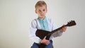 Russian boy in national dress plays the balalaika. Royalty Free Stock Photo