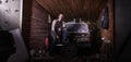 Russian car mechanic in a garage repairs the car