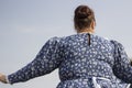 Russian clothing in folklore. Woman in traditional dress. A woman aged taken from the back.