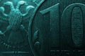 Russian coins of 10 rubles on both sides close-up. Dark dramatic background or wallpaper in turquoise color. Textured scratched