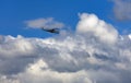 Russian combat helicopter is flying against the background of clouds in the summer sky