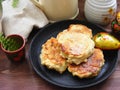 Russian cuisine : crepes pancakes on black cast iron with oak flakes on wooden background with rustic milk jug and nesting dolls