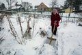 Elderly woman cleans the snow near his home. Royalty Free Stock Photo