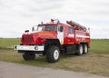 Russian fire truck of red color with retractable ladders stands on the airfield