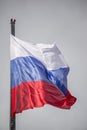Russian flag against the background of a cloudy sky, waving in the wind Royalty Free Stock Photo