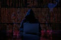 The russian flag is made of binary code, the hacker in front with his laptop is silhouetted