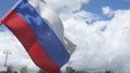 Russian flag waving from wind against green trees and city flashlights