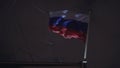 Russian flag waving in wind on ship`s flagpole. Night sky at background