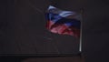 Russian flag waving in wind on ship`s flagpole. Night sky at background