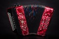 Russian folk instruments.Red bayan on a black background.Russian accordion Royalty Free Stock Photo