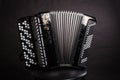 Russian folk musical instruments.Black Accordion isolated on a dark background