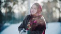 Russian folklore - beautiful russian woman in a scarf is clapping her hands and smiling